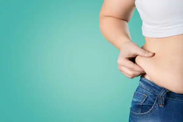Image of woman pinching her love handles to show weight gain Loughborouogh
