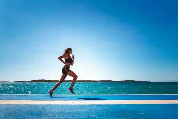 Woman running showing strong leg muscle Loughborouogh